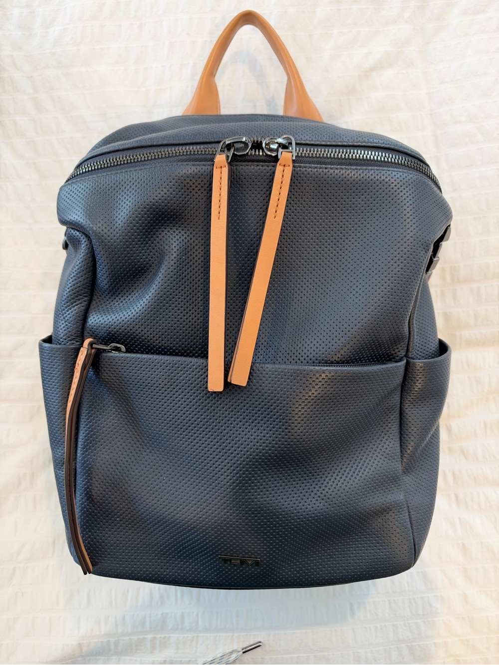 TUMI Navy Perforated Leather Backpack with tan/cognac leather trim